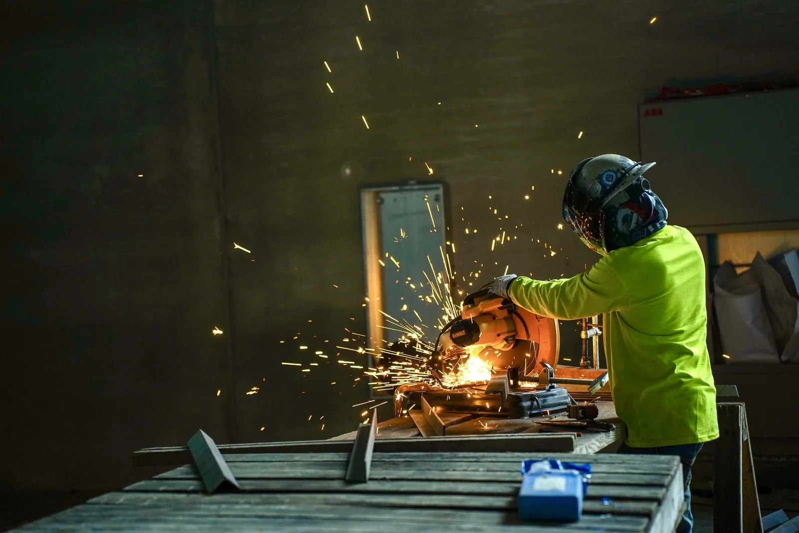 Worker cutting steel with sparks flying on a job site