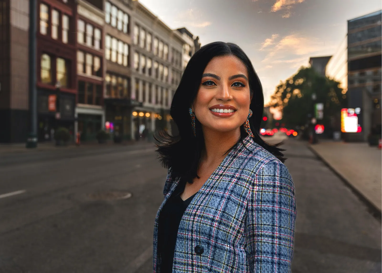 Professional in a plaid blazer on a downtown Louisville street at dusk